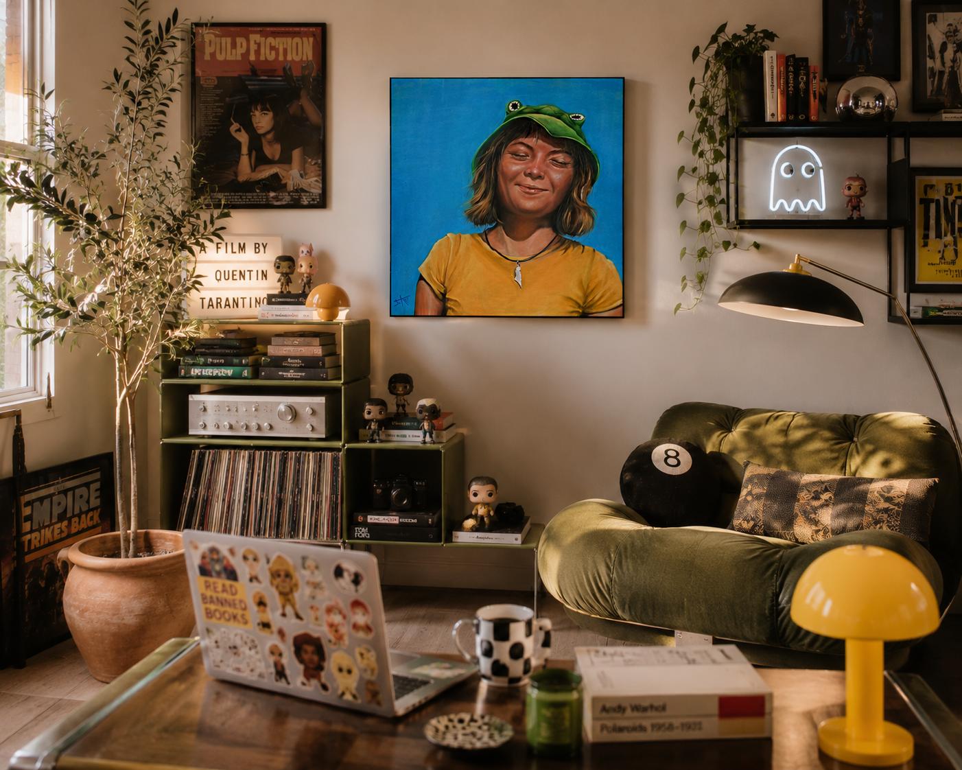 A colorful canvas print of a woman with a green frog hat on a bright blue background, styled in a cozy, dimly lit living room with a green couch, lamp, and record shelves.